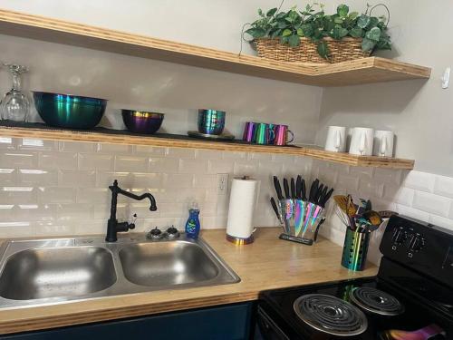 a kitchen counter with a sink and a stove at Indigo DowntownWalkable KingBed in Raleigh
