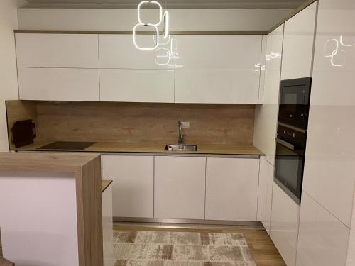 a kitchen with white cabinets and a sink at Violin 2 bedroom Apartment downtown Prizren in Prizren