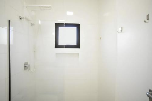 a bathroom with a window and a shower at Paraíso Pé na Areia em Boracéia - Desfrute da conveniência de ter a praia no seu quintal in São Sebastião