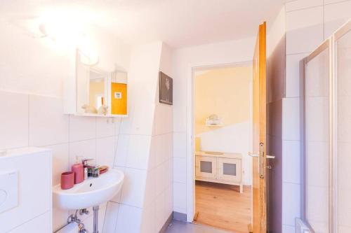 ein weißes Badezimmer mit einem Waschbecken und einem Spiegel in der Unterkunft - 3-Bedroom Apartment Luxury: Central & Spacious in Duisburg & Big TV and Kitchen - in Duisburg