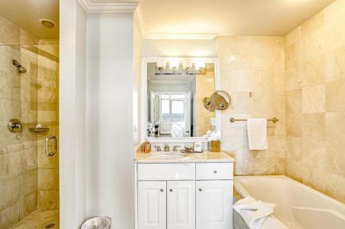 a bathroom with a sink and a tub and a toilet at Marco Beach Ocean Resort 1202 in Marco Island