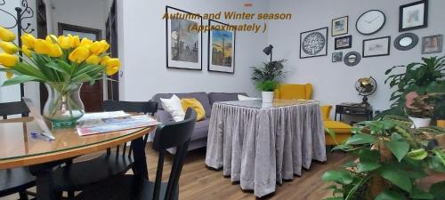 una sala de estar con una mesa con un jarrón de flores amarillas en Apartamentos Los Descalzos Free Parking, en Ronda