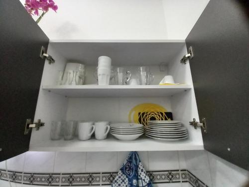 a cupboard with plates and cups and dishes on it at Apartman Stari most - Old Bridge in Bečej