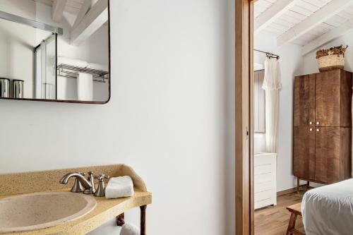 bagno con lavandino e specchio di Apartamentos turísticos EL PATIO DEL NOGAL a Guadalupe