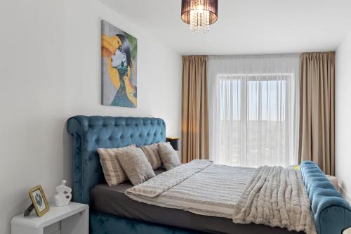 a bedroom with a blue bed and a window at The Address Bucharest in Bucharest