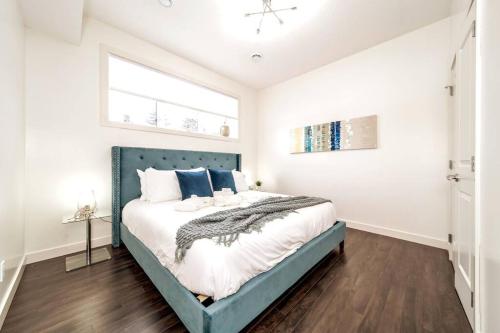 1 dormitorio con 1 cama con cabecero azul en Chic Suite - Long Stays - King Bed - Fireplace & WiFi, en Edmonton