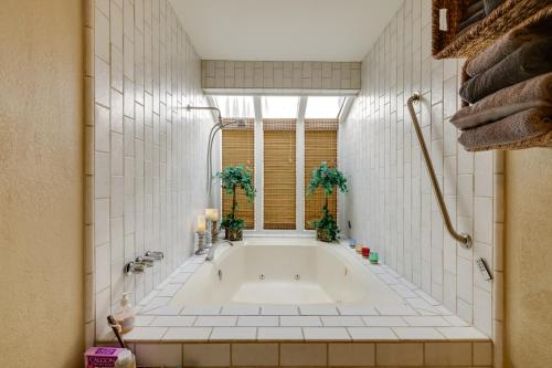 een badkamer met een bad en een raam bij Deluxe Townhome with Deck, 2 Mi to Downtown Modesto! in Modesto