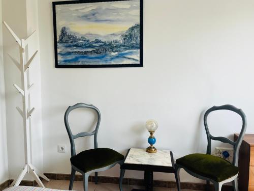 Art House في أليكانتي: كرسيين وطاولة في غرفة مع لوحة