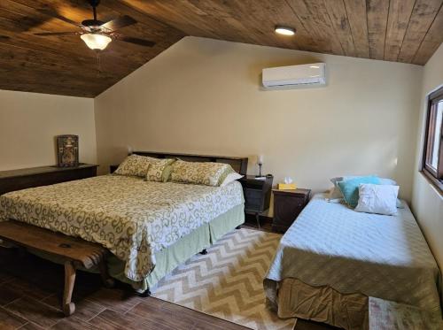 a bedroom with two beds and a ceiling fan at Loft Candelaria Antigua in Antigua Guatemala