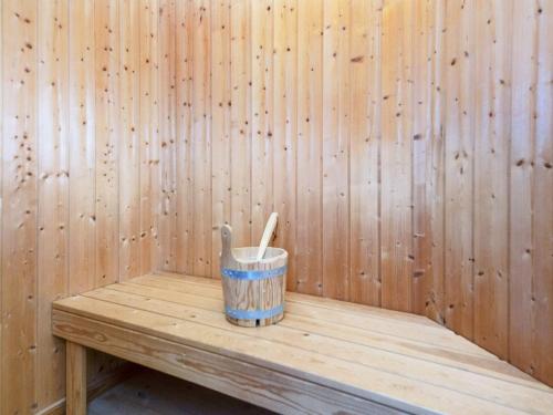a wooden bucket sitting on a wooden bench in a sauna at 4 star holiday home in Sydals-By Traum in Neder Lysabild