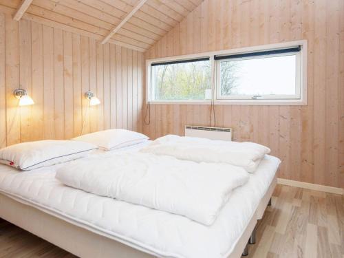 Cette chambre comprend un grand lit blanc et une fenêtre. dans l'établissement Holiday home Sydals XCII, à Neder Lysabild