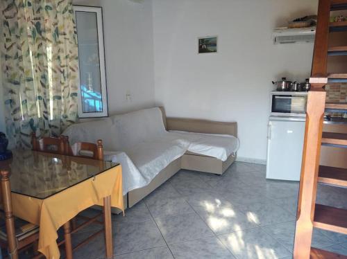 Cet appartement comprend une chambre avec un lit et une table ainsi qu'une cuisine. dans l'établissement A CASA D'IRENE, à Votsalákia