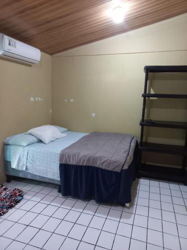 a small bedroom with a bed and a heater at La Casa de Cachi in Paquera