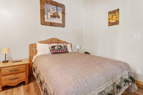 a bedroom with a bed and a wooden dresser with a night stand at Black Forest Lodge in Big Bear Lake
