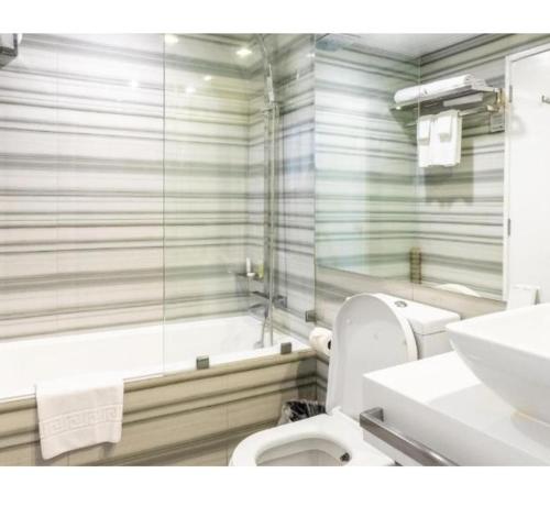 y baño con aseo, ducha y lavamanos. en Astoria Palawan, en San Jose