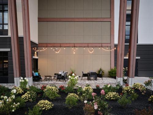 a patio with chairs and flowers in front of a building at Great Blue Heron Hotel in Port Perry