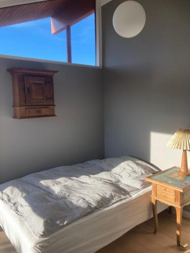 a bedroom with a bed and a table with a lamp at Værelse, bad og toilet i villa in Næstved