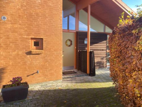 a brick building with a door and a window at Værelse, bad og toilet i villa in Næstved