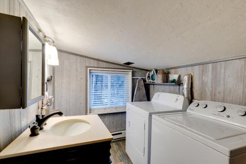 a laundry room with a washing machine and a sink at Rustic Log Cabin with Studio about 5 Mi to Pikes Peak! in Green Mountain Falls