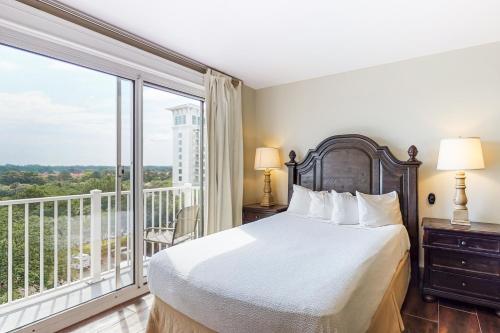 a bedroom with a bed and a balcony at The Grand #2611 in Destin