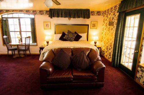a bedroom with a bed and a leather couch at Black Forest Lodge in Big Bear Lake
