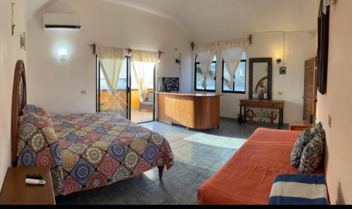 a bedroom with a bed and a desk in a room at Hotel Joya Del Mar in Barra de Navidad