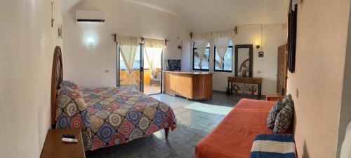a bedroom with a bed and a desk in a room at Hotel Joya Del Mar in Barra de Navidad