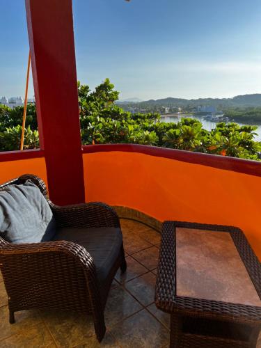 Un balcón con una silla, una mesa y vistas. en Hotel Joya Del Mar, en Barra de Navidad
