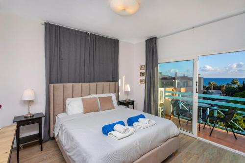 a bedroom with a bed with a view of the ocean at Palm Beach Apartment by TrulyCyprus in Limassol
