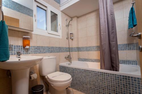 a bathroom with a toilet and a sink and a shower at Palm Beach Apartment by TrulyCyprus in Limassol