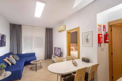 a living room with a blue couch and a table at Palm Beach Apartment by TrulyCyprus in Limassol
