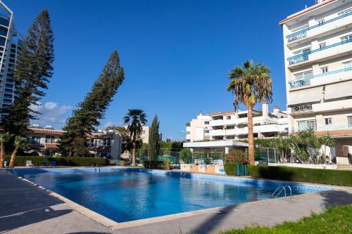 a large swimming pool in front of a building at Palm Beach Apartment by TrulyCyprus in Limassol