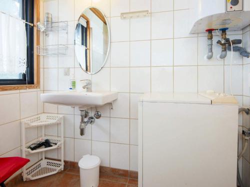 ein weißes Badezimmer mit einem Waschbecken und einem Spiegel in der Unterkunft Holiday home Sydals XXXI in Neder Lysabild