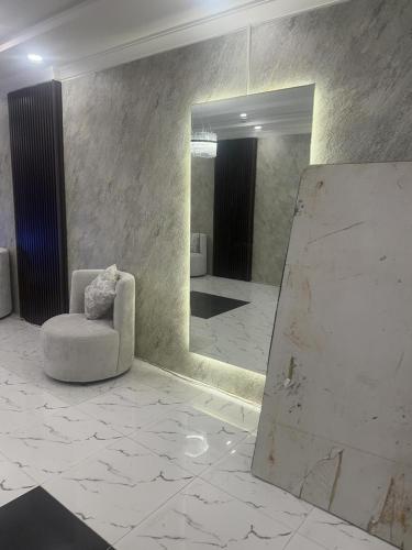 a white room with a chair and a mirror at كازا رست للوحدات السكنية in Ḩayy aş Şāliḩīyah