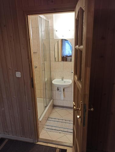 a bathroom with a shower and a sink at Brzoskwiniowy Dom in Bańska Niżna