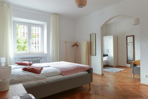 a white bedroom with a bed and a window at FAWAY Charmante Atmosphäre - Parken - Netflix in Ingolstadt