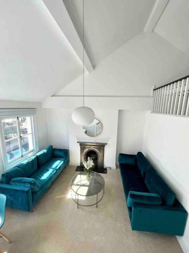 sala de estar con 2 sofás azules y chimenea en Fab split level Kensington Apartment en Londres