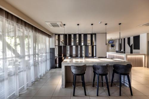 a kitchen with a large island with bar stools at Almond Business Hotel in Nicosia
