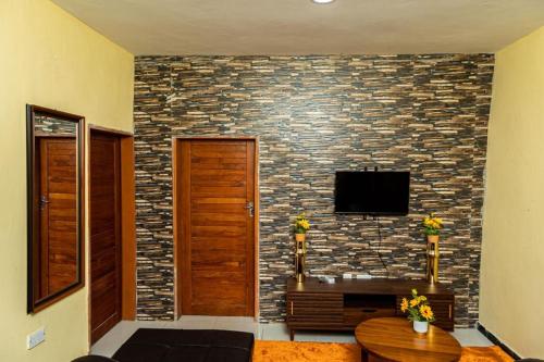 a living room with a stone wall and a tv at Planet Golf - foxdale in Foxdale Estates