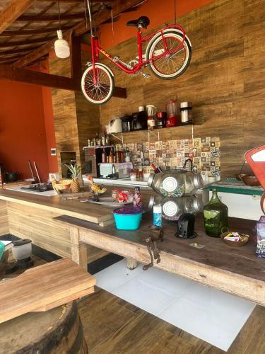 a kitchen with a table with a bike on the wall at Chácara de Alto Padrão in Nova Iguaçu