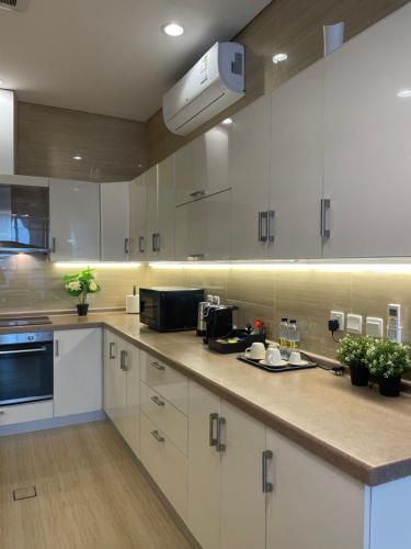 una cucina con mobili bianchi e un piano di lavoro di شقة مميزة بحي الملقا a Riyad