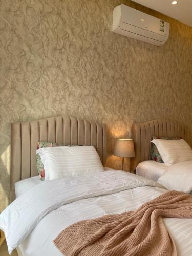 una camera da letto con due letti e un condizionatore a parete di شقة مميزة بحي الملقا a Riyad