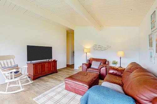 a living room with a couch and a television at Gathering Together Cabin in Gig Harbor