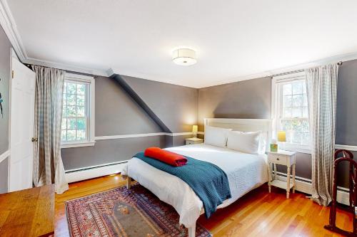 um quarto com uma cama e duas janelas em Goldfinch Cottage em Newburyport