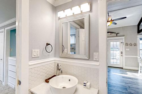 uma casa de banho branca com um lavatório e um espelho em The Swordfish Sanctuary em Galveston