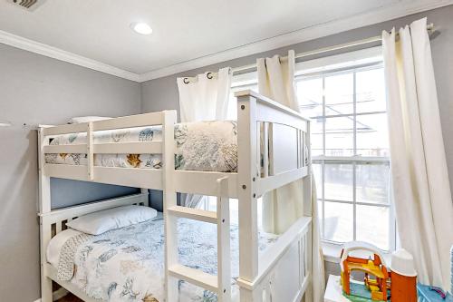 a bedroom with two bunk beds and a window at The Swordfish Sanctuary in Galveston
