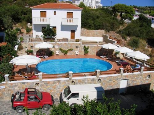 a villa with a swimming pool in front of a building at Elena Studios in Patitiri