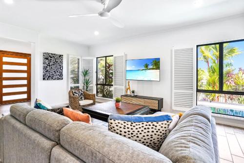 a living room with a couch and a table at Flagship Villa in Trinity Beach