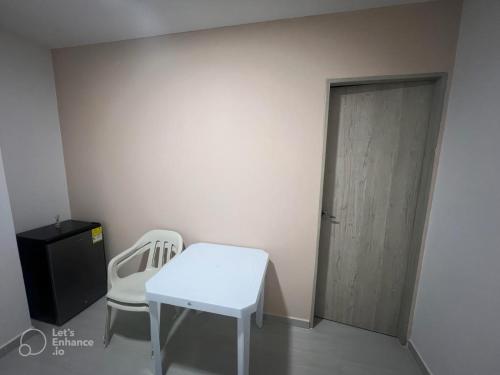 a room with a white table and two chairs and a door at EDIFICIO BUENOS AIRES 1 Habitación in Sincelejo