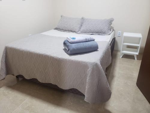 a bed with two towels sitting on top of it at Hospedagem Costa BNU - PLUS in Blumenau